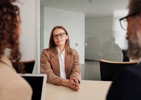 Young woman attending a job interview in a modern office, showcasing confidence and professionalism.